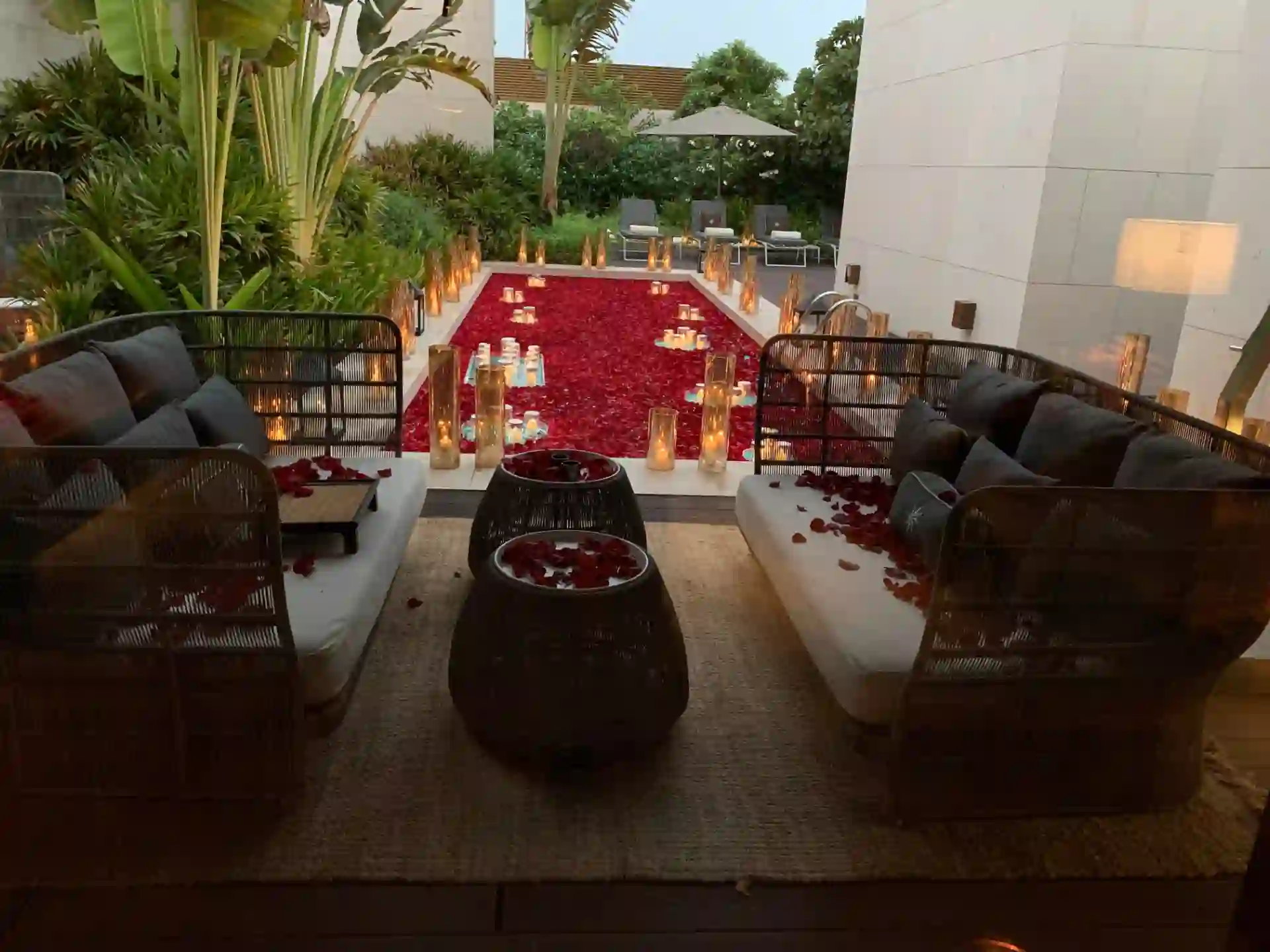Private pool decorated with rose petals and candles at dusk