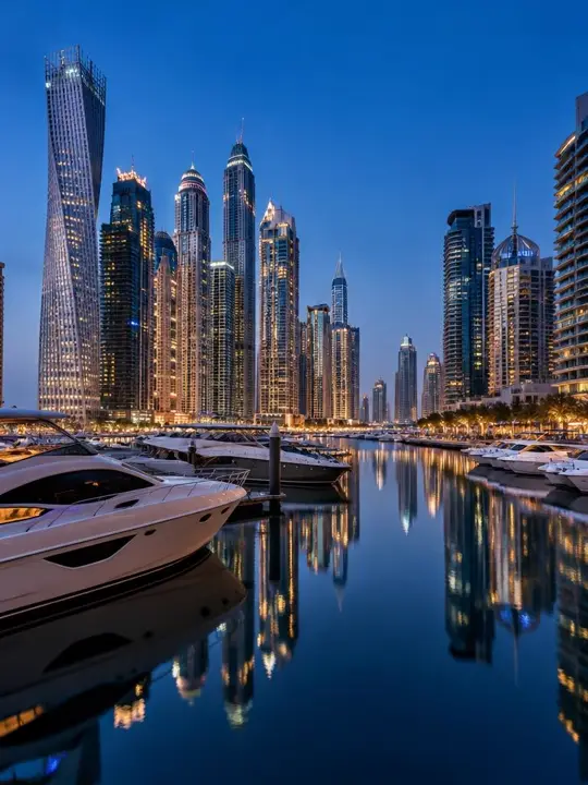 Dubai Marina towers and yachts reflected at blue hour